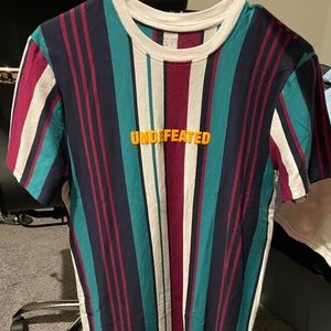 Undefeated t-shirt. Multi colored striped shirt